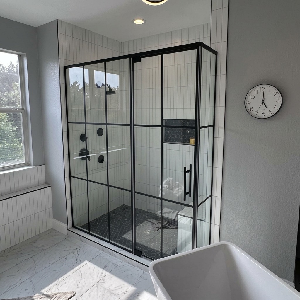 Glass shower enclosure with black grid framing beside a freestanding tub, installed by Shower Doors of Dallas