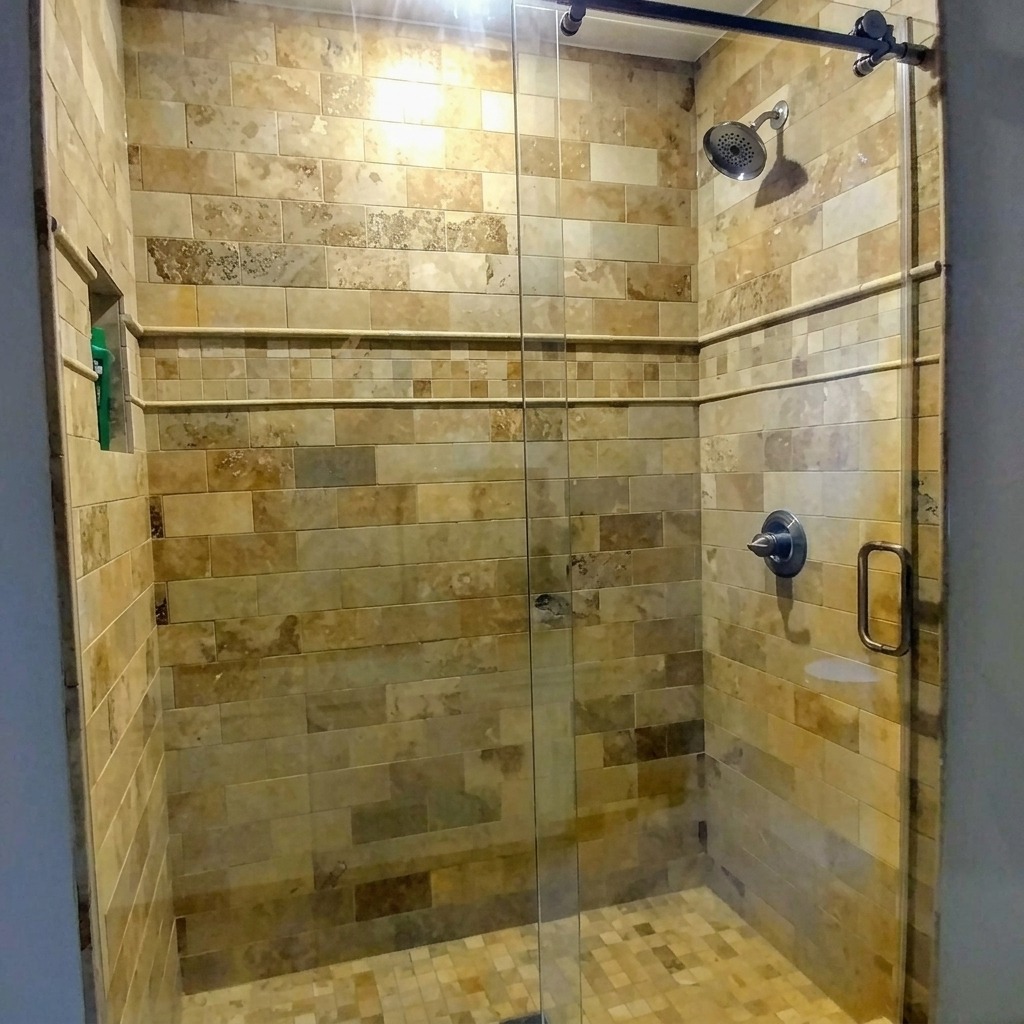 Frameless sliding glass shower door with stone tile walls