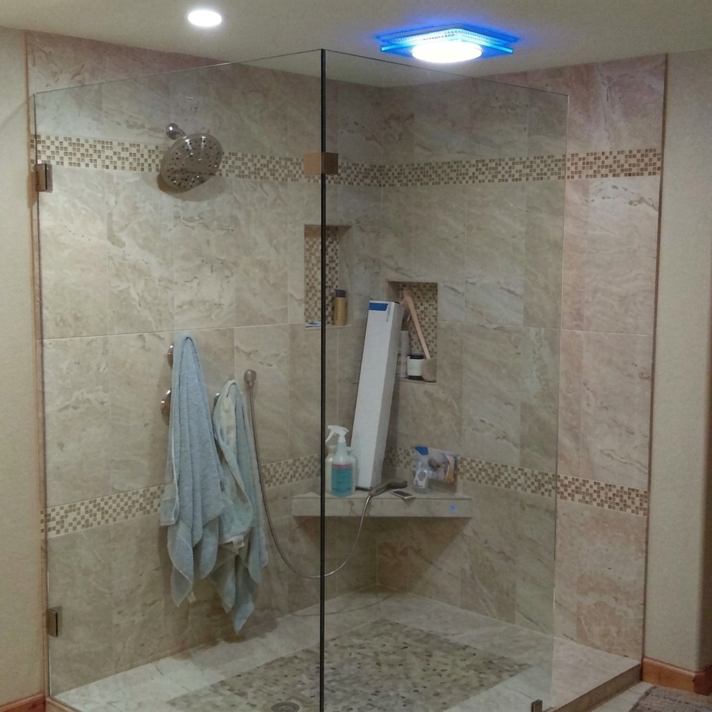 Frameless corner shower glass with a hinged door and fixed panel
