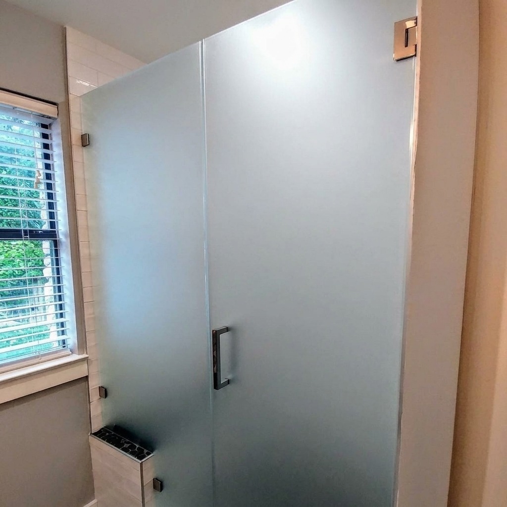 Frosted glass frameless shower door and panel with a black handle