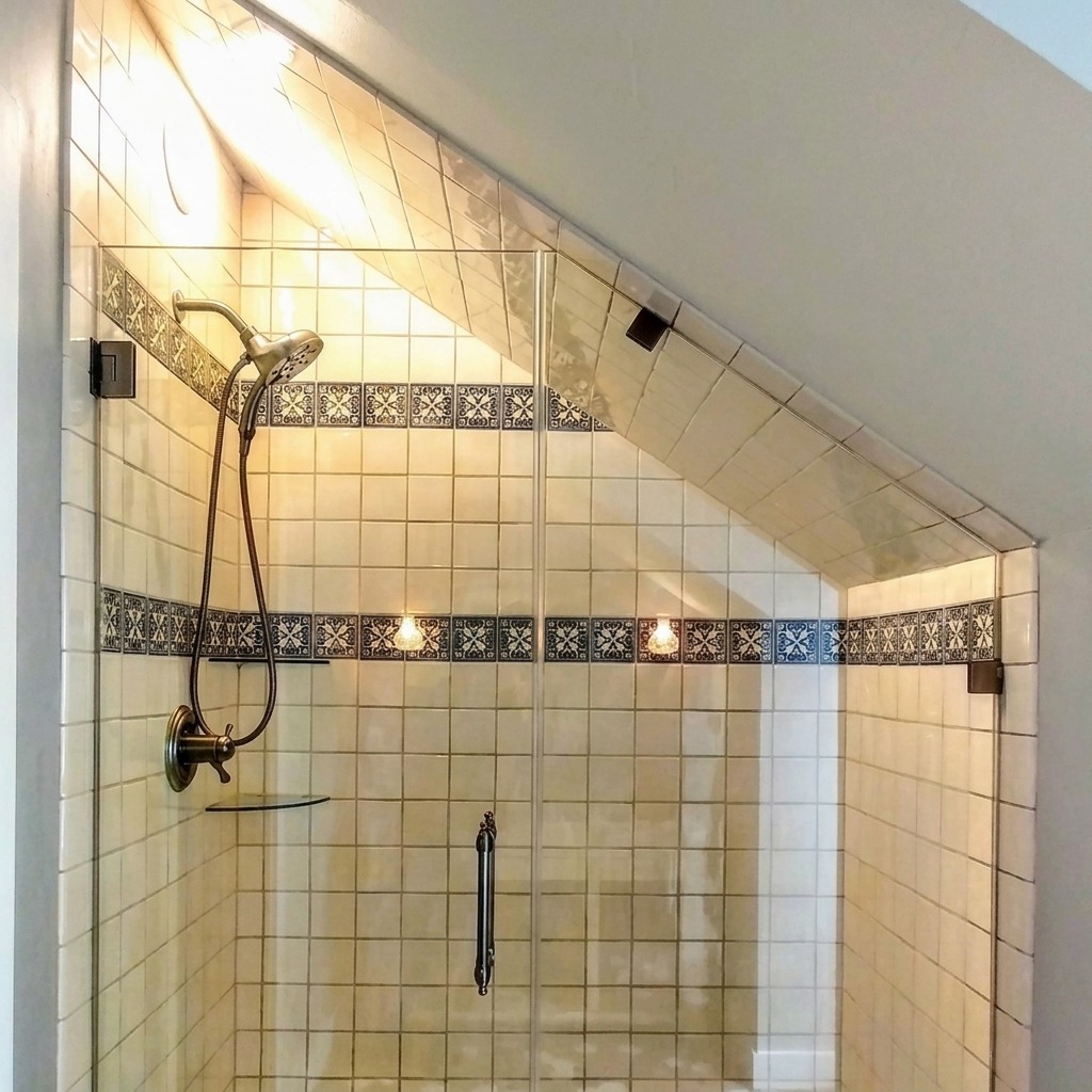 Custom raked frameless shower glass cut to a sloped ceiling