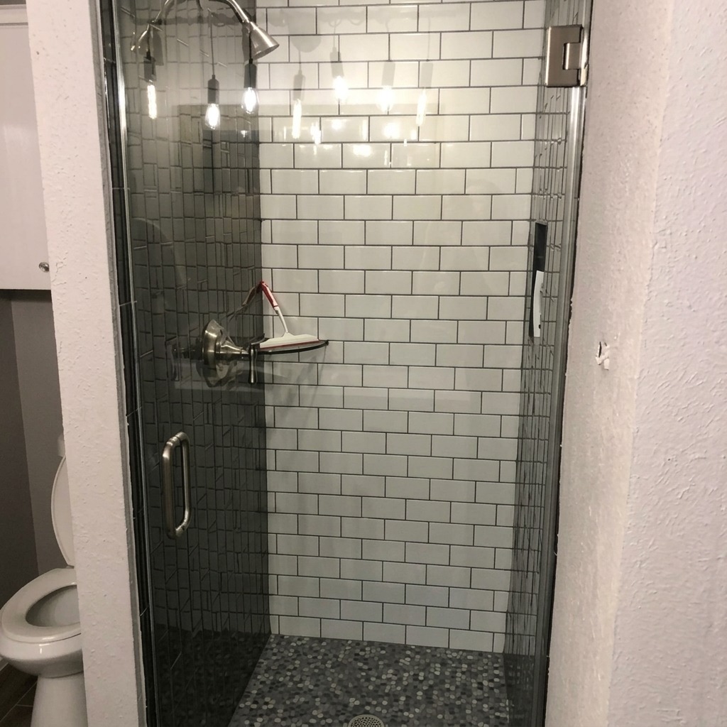Single frameless glass shower door with a pebble tile floor