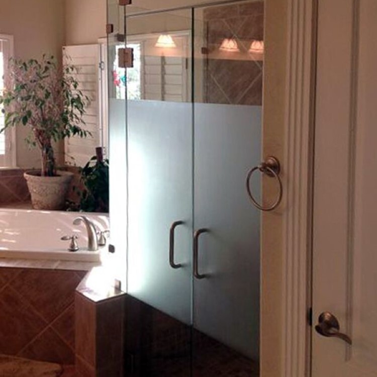 Frameless double shower doors with an etched glass band