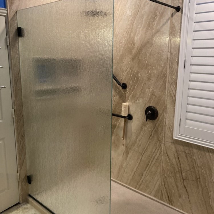 Frameless shower door in textured rain glass