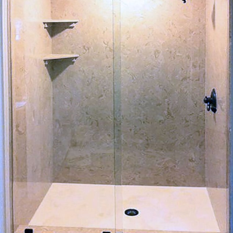Frameless sliding glass shower door on a travertine shower
