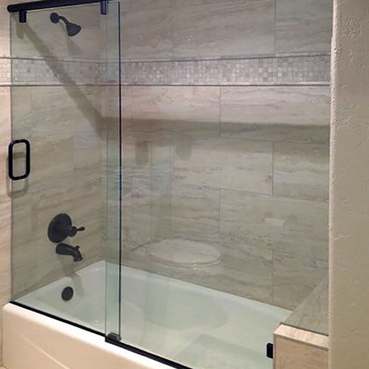 Frameless sliding glass tub enclosure with matte black hardware