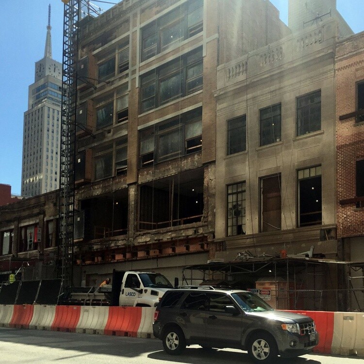 Historic building facades under renovation behind construction barriers