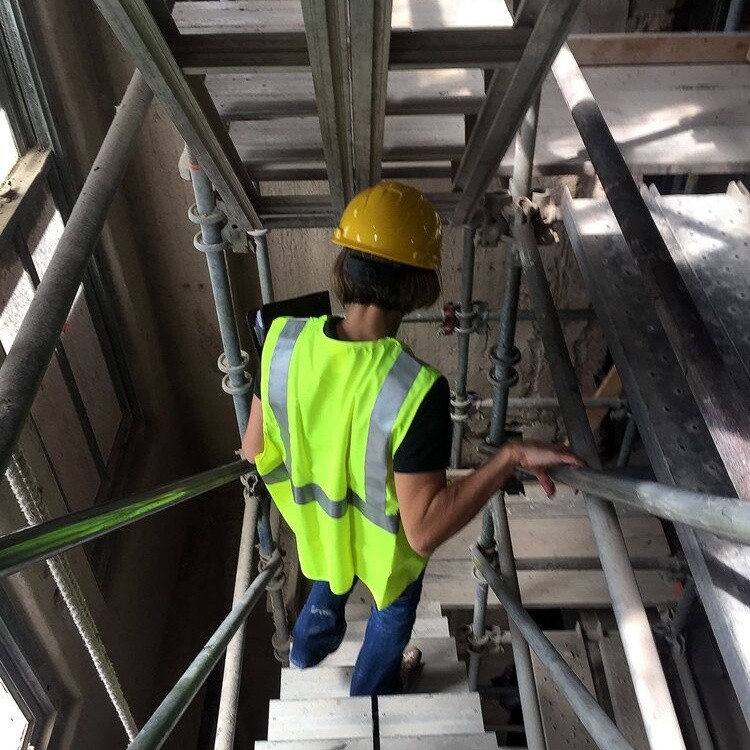 Crew member climbing interior scaffolding during the renovation