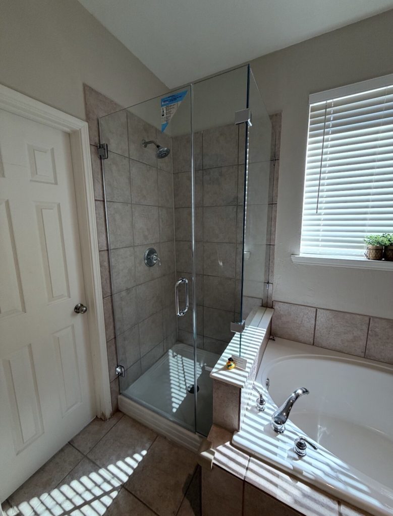 Frameless 90-degree shower enclosure on a tiled pony wall in Sachse, TX