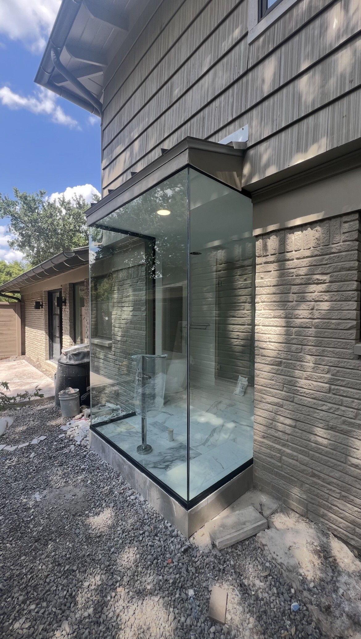 Exterior view of the three-panel glass enclosure set in U-channel framing in Dallas, TX