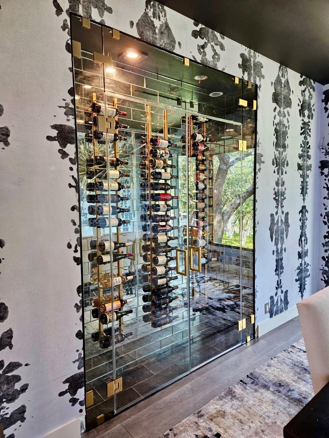 Custom glass wine room with frameless panels and a glass door in a Dallas, TX home