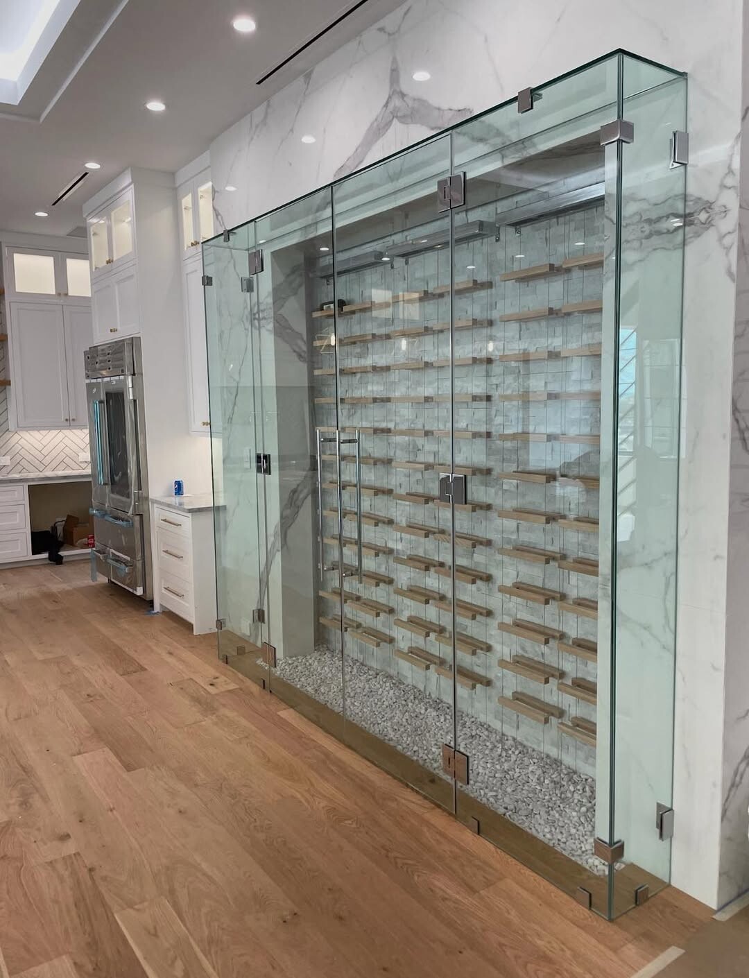 Frameless glass wine room enclosure with a glass door in a second Dallas, TX home