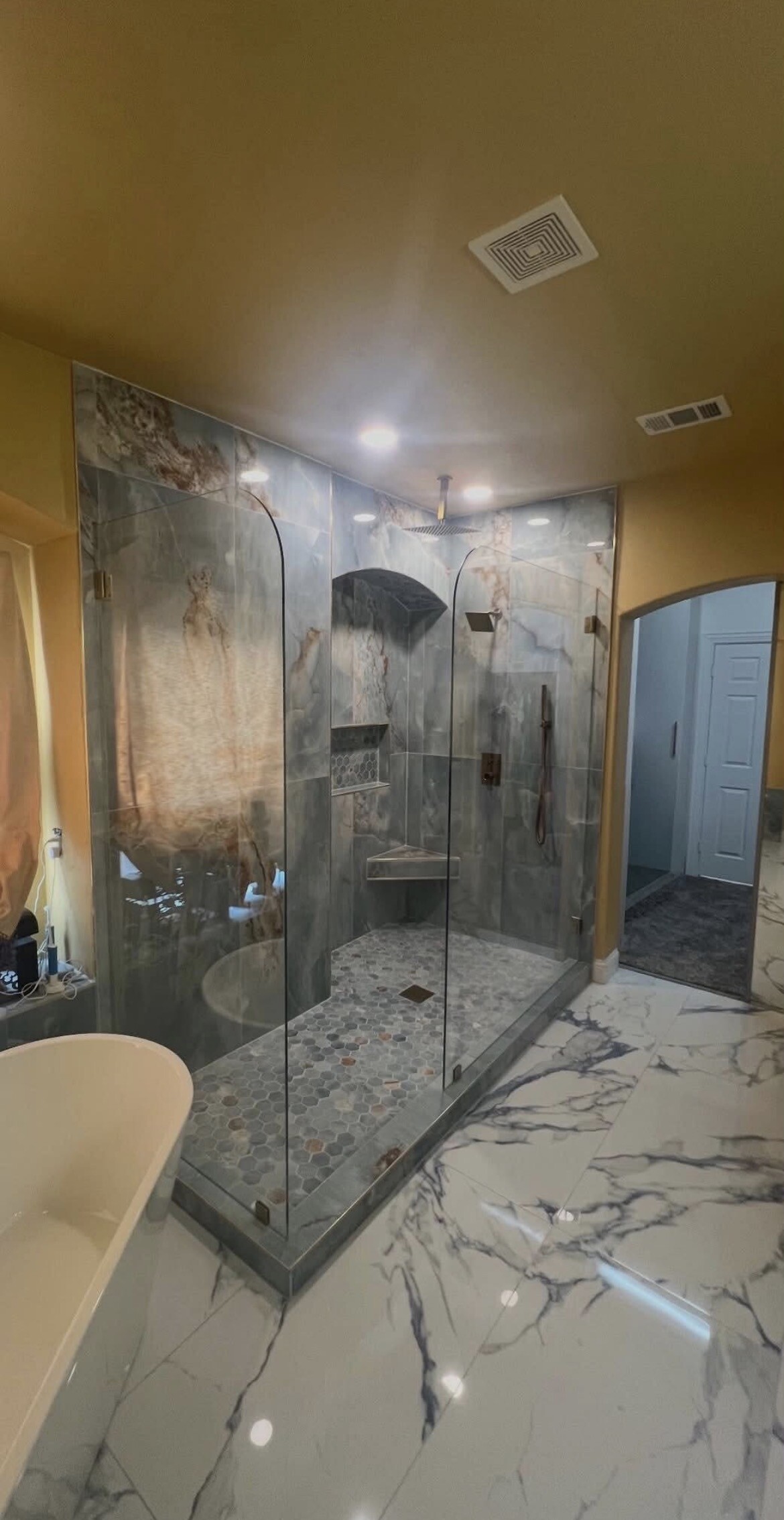 Corner shower enclosure with two radius-corner glass splash panels in Denton, TX