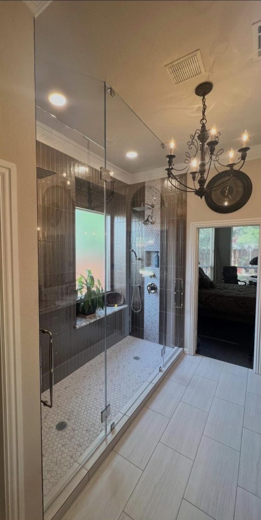 Frameless inline shower with a floor-to-ceiling center panel and two hinged doors in Dallas, TX