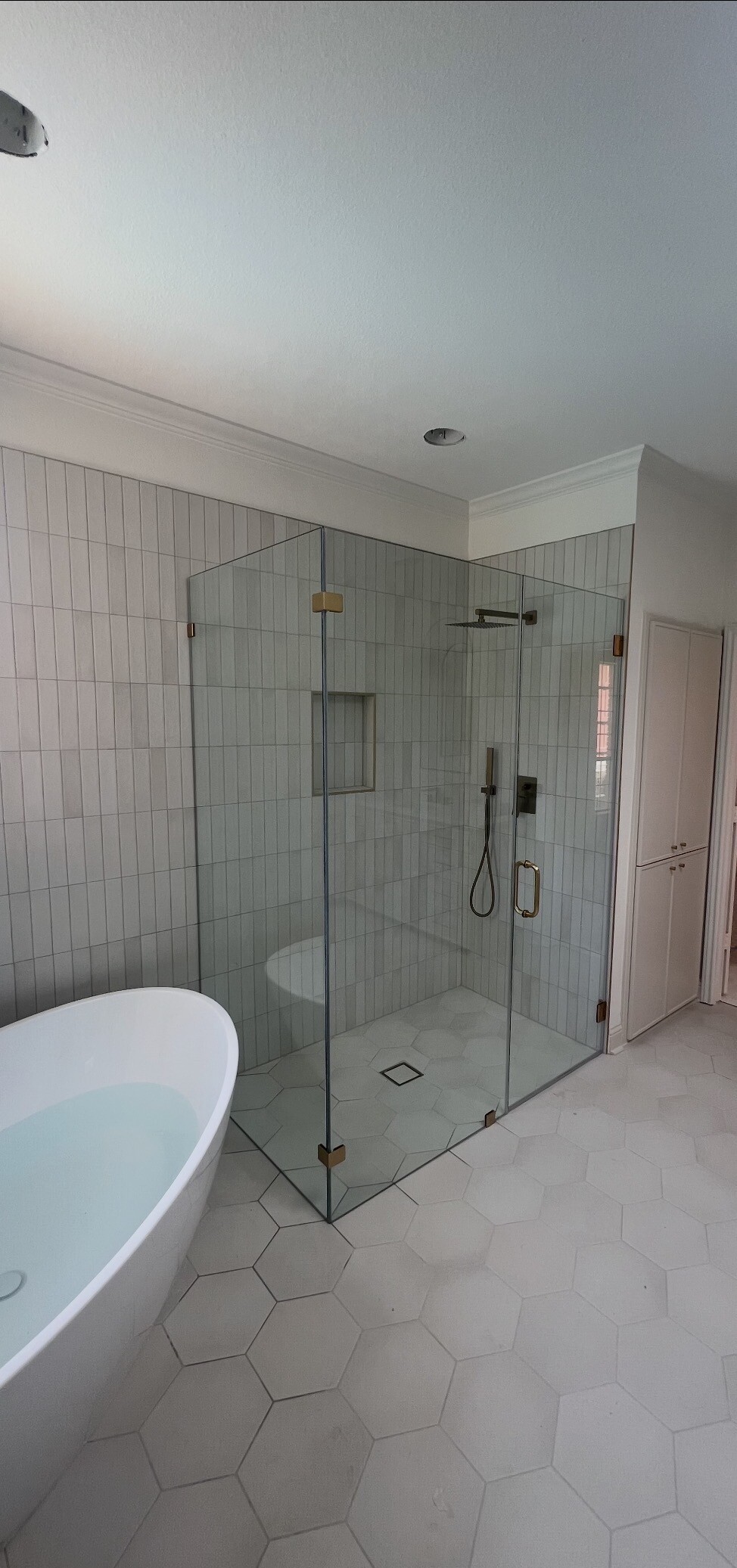 Second view of the frameless 90-degree shower enclosure behind a freestanding tub in Plano, TX