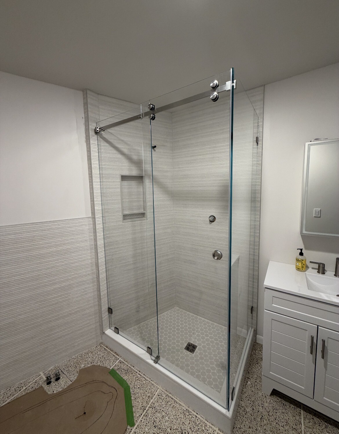 90-degree Serenity sliding shower door with low iron glass and a brushed nickel top roller next to the vanity in Plano, TX