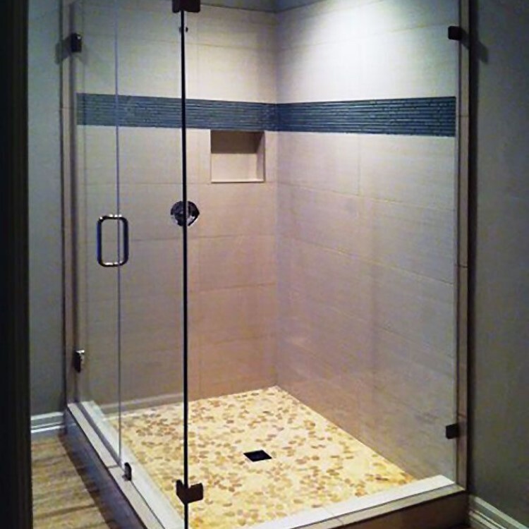 Frameless 90-degree shower enclosure with a blue mosaic accent band and a pebble floor