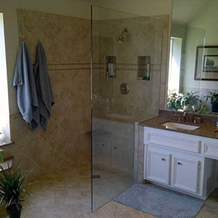 Frameless glass shower panel in a walk-in shower beside a vanity