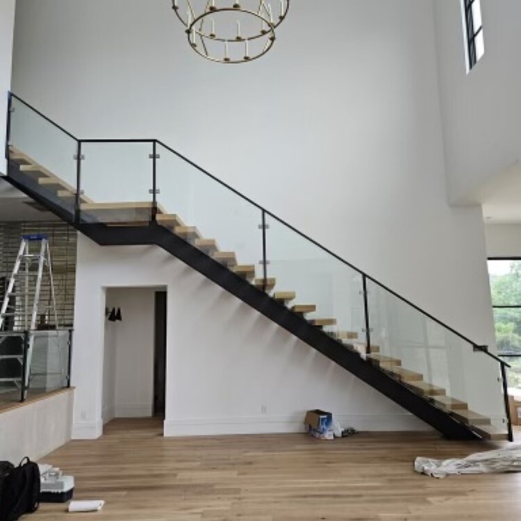 Glass panel railing on an open steel staircase