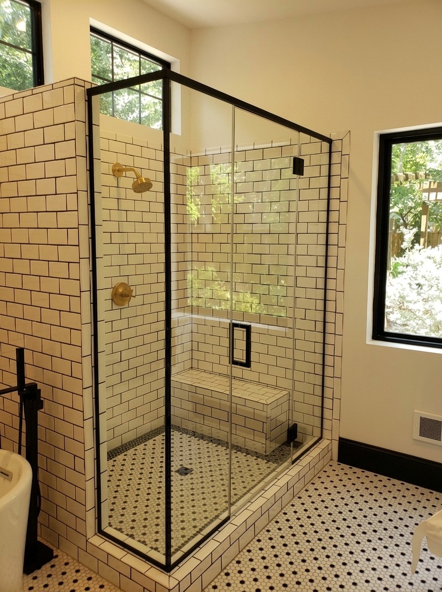 Glass shower enclosure with black trim and subway tile in a remodeled Dallas bathroom