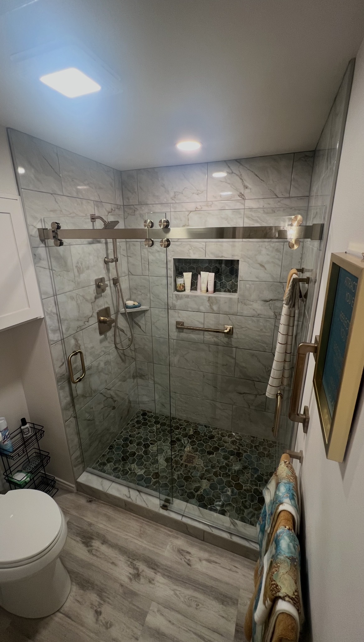 Cambridge sliding shower enclosure with brushed bronze exposed roller hardware in Dallas, TX