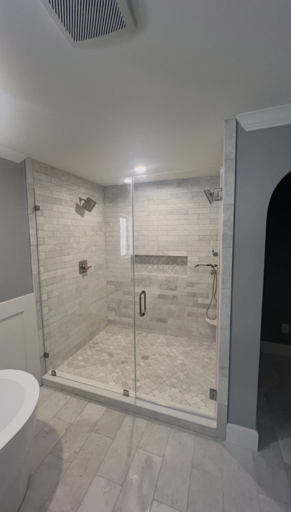 Frameless inline shower enclosure with low-iron glass and polished nickel hardware in Dallas, TX